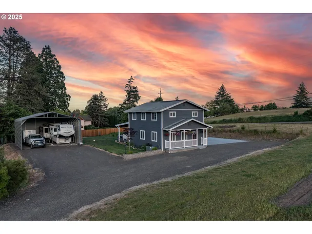 a view of a house with a yard and sitting area