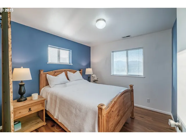 a bedroom with a bed and a lamp on dresser