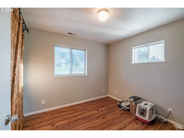 a view of a room with wooden floor closet and window