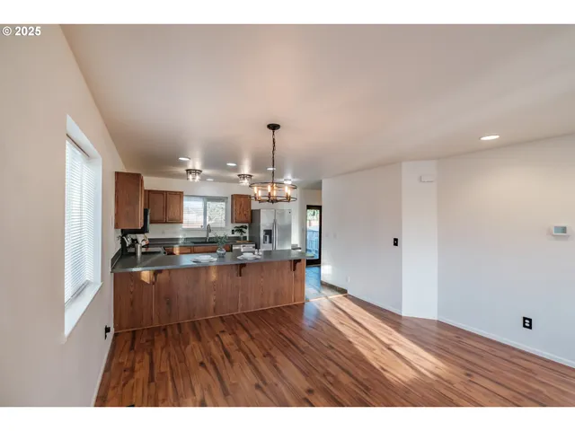 a kitchen with stainless steel appliances granite countertop a stove and a wooden floors