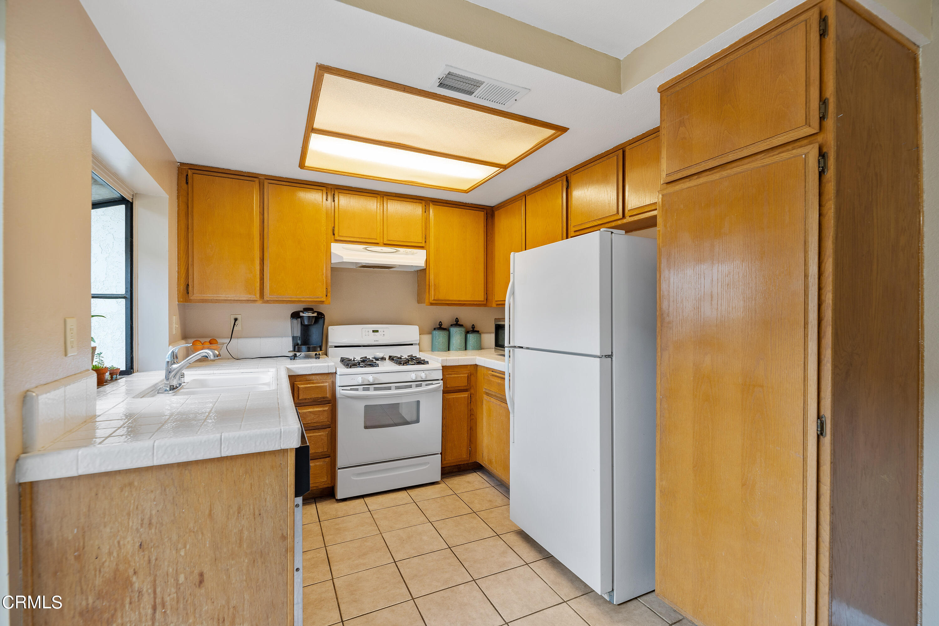 3554 Olds Road Oxnard, CA 93033 - Photo 9 of 27 a kitchen with a refrigerator sink stove and cabinets