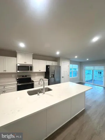 a large kitchen with kitchen island a sink stainless steel appliances and cabinets
