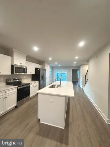 a kitchen with a sink a counter top space stainless steel appliances and cabinets