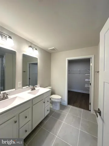a spacious bathroom with a granite countertop sink toilet and mirror