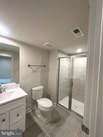 a bathroom with a toilet a sink and glass door