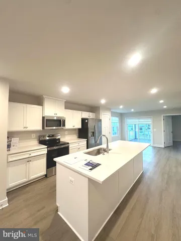 a kitchen with stainless steel appliances kitchen island sink refrigerator and stove