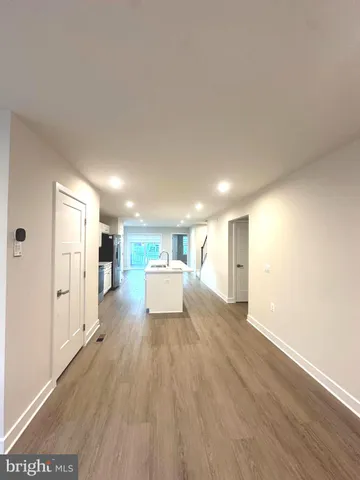 a view of a big room with wooden floor and windows