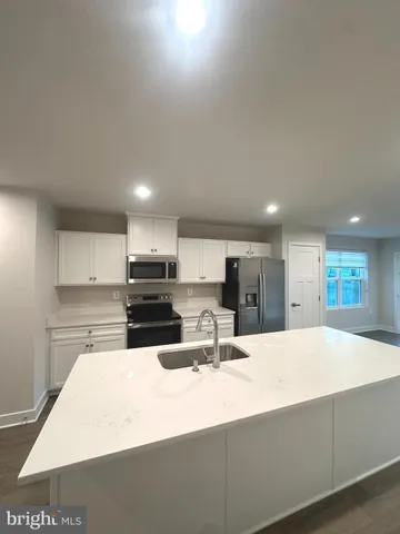 a kitchen with kitchen island sink stove and refrigerator