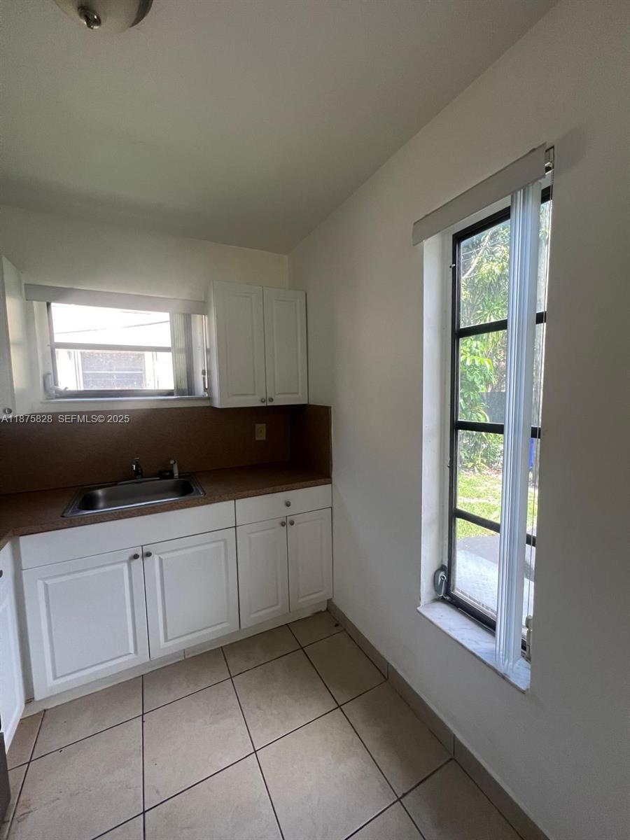 1670 Harding Street Hollywood, FL 33020 - Photo 18 of 19 a kitchen with white cabinets and window