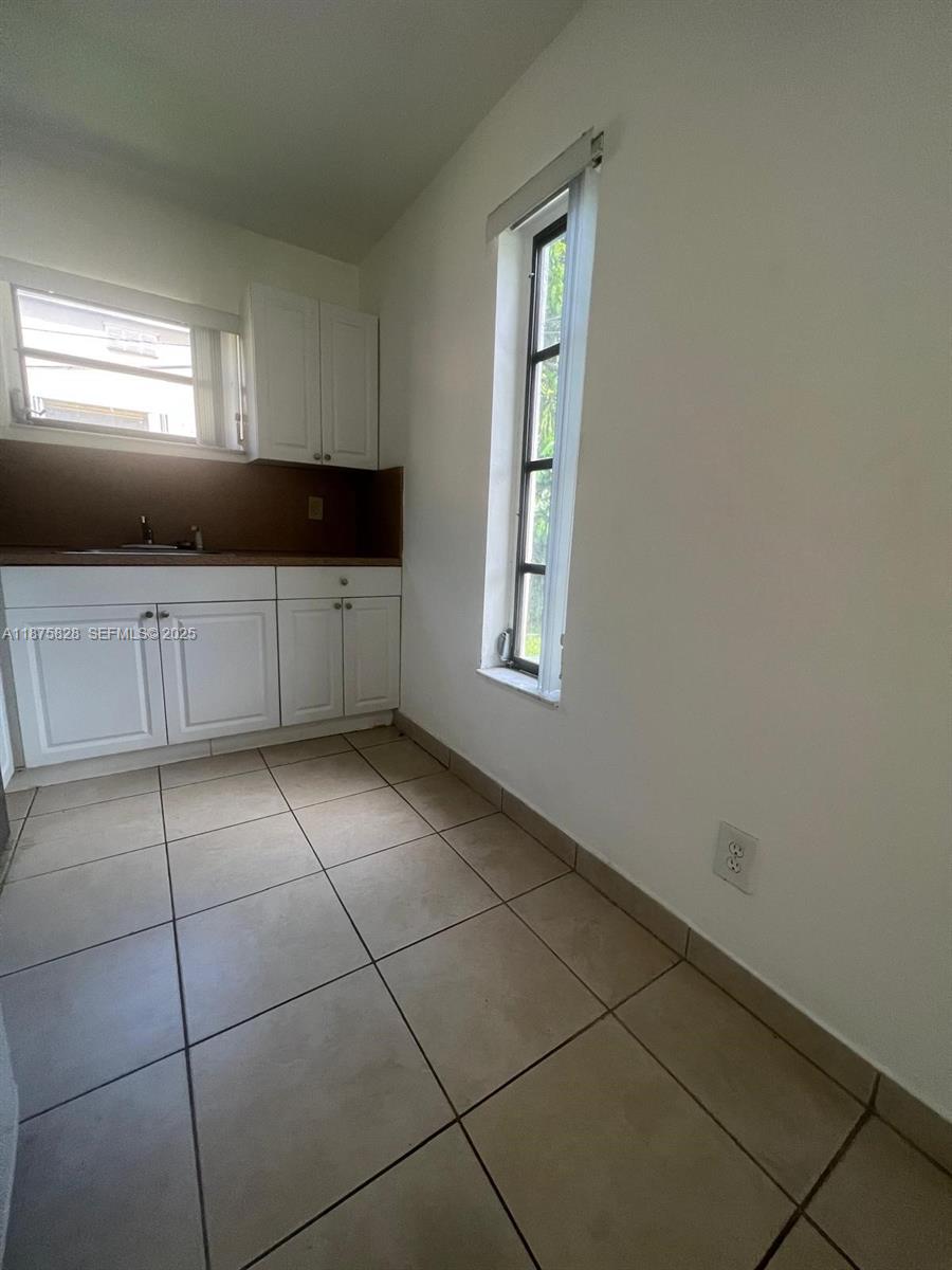 1670 Harding Street Hollywood, FL 33020 - Photo 19 of 19 a kitchen with granite countertop white cabinets and window