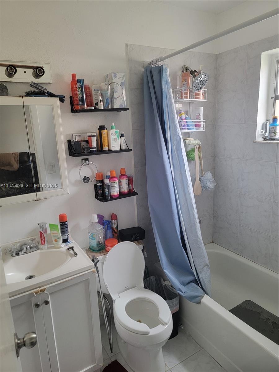 1670 Harding Street Hollywood, FL 33020 - Photo 4 of 19 a bathroom with a sink a toilet and a shower curtain