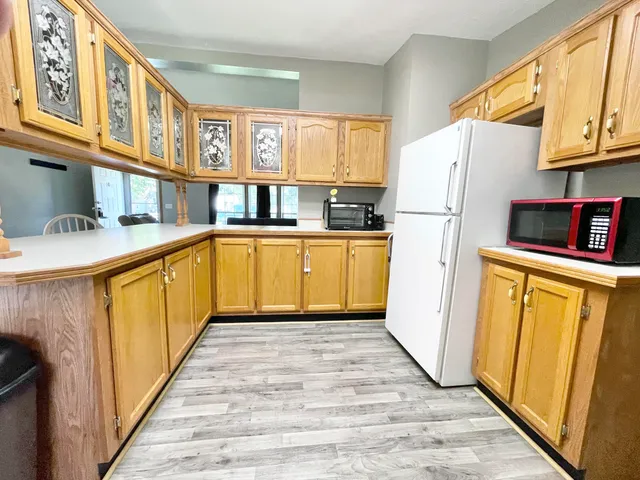 a kitchen with stainless steel appliances granite countertop a refrigerator a stove a sink and dishwasher with wooden floor