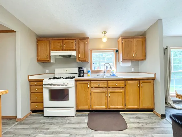 a kitchen with stainless steel appliances granite countertop a stove a sink and a microwave