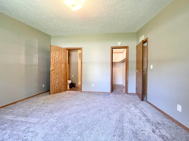 an empty room with closet and windows