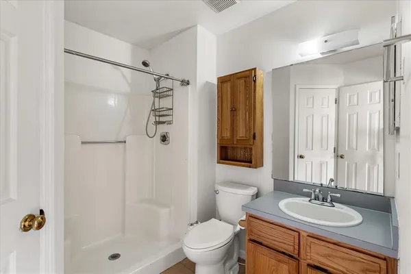 a bathroom with a sink a toilet and shower