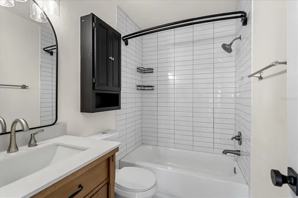 a bathroom with a bathtub shower sink vanity and toilet