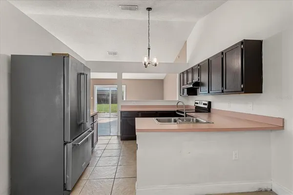 a kitchen with stainless steel appliances granite countertop a sink refrigerator stove and microwave