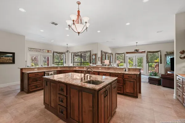 a kitchen with stainless steel appliances granite countertop table chairs sink and cabinets