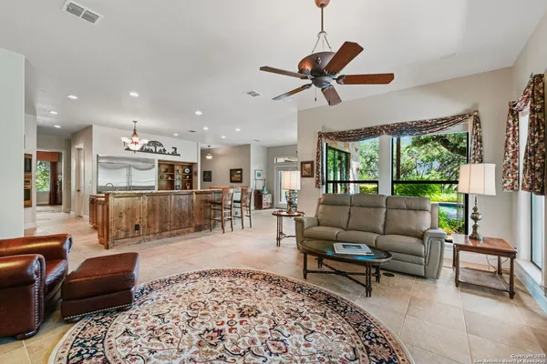 a living room with furniture a floor to ceiling window and a flat screen tv