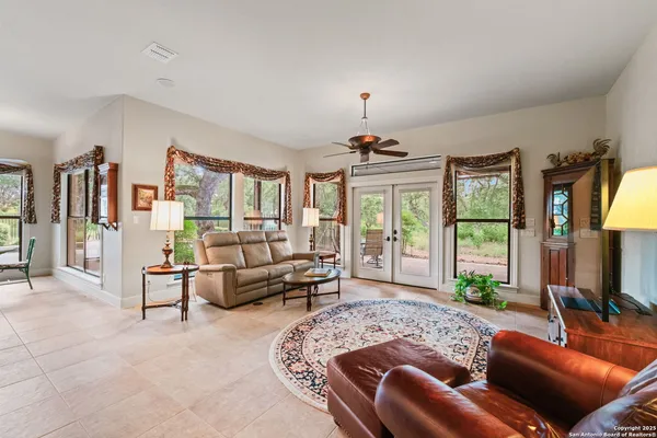a spacious bedroom with a bed a couch and a chandelier