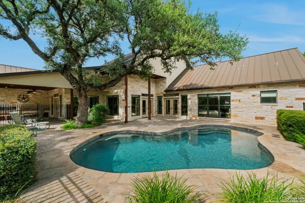 a view of a house with swimming pool and sitting area