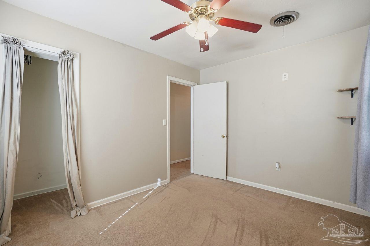 6444 Walnut Street Milton, FL 32570 - Photo 22 of 33 an empty room with closet and a chandelier fan