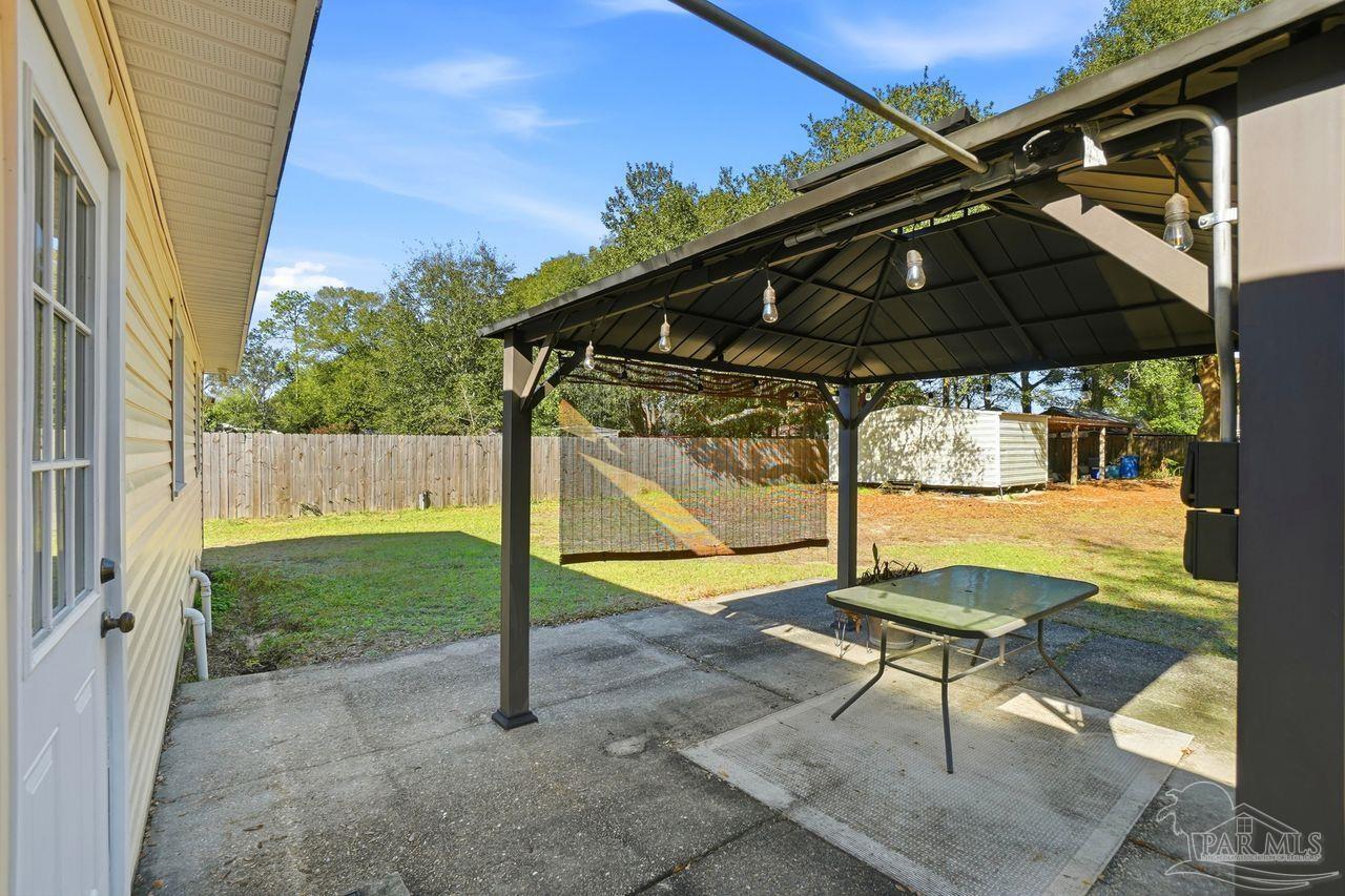 6444 Walnut Street Milton, FL 32570 - Photo 25 of 33 a backyard of a house with table and chairs