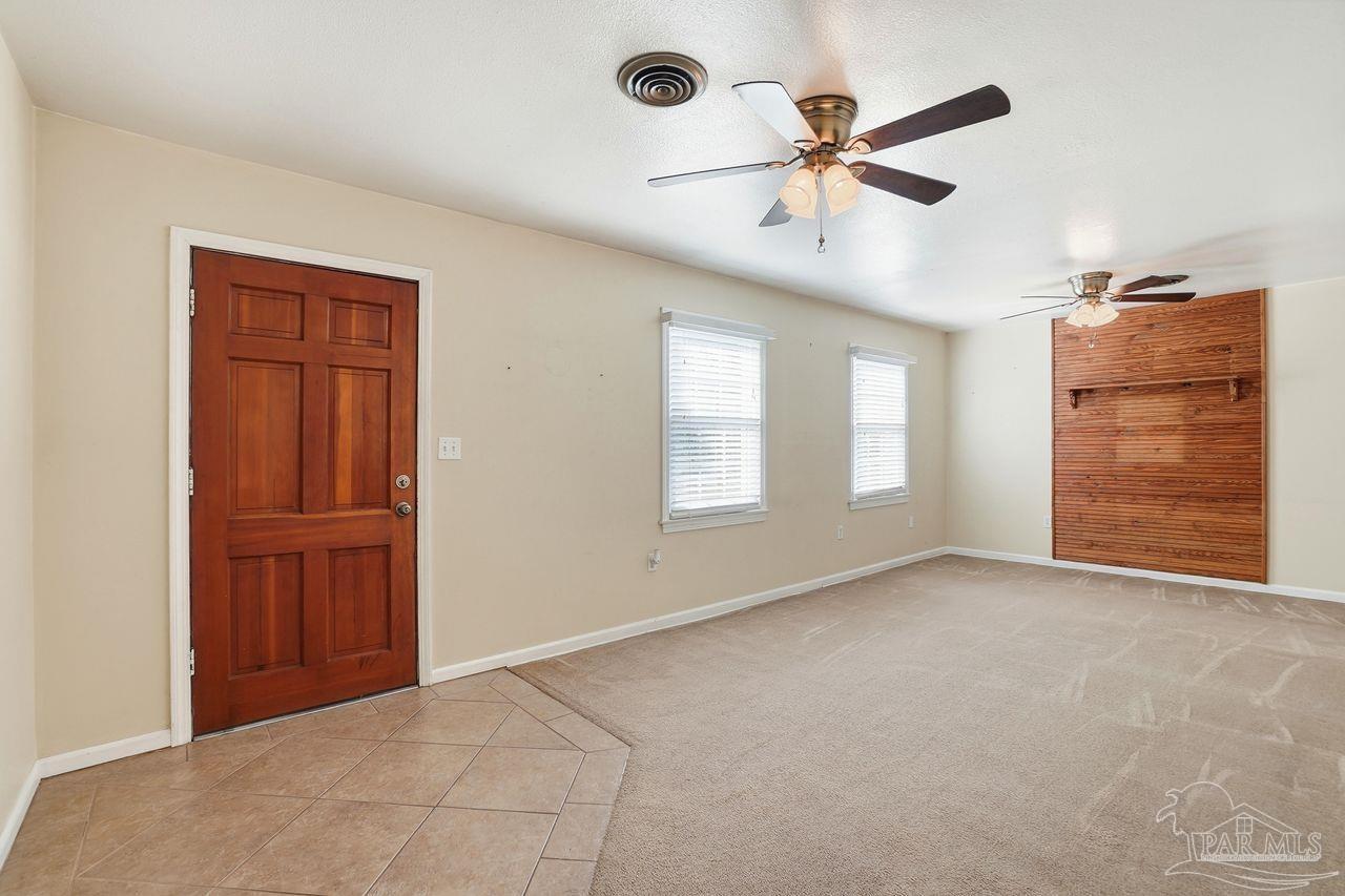 6444 Walnut Street Milton, FL 32570 - Photo 7 of 33 a view of an empty room with a ceiling fan and window