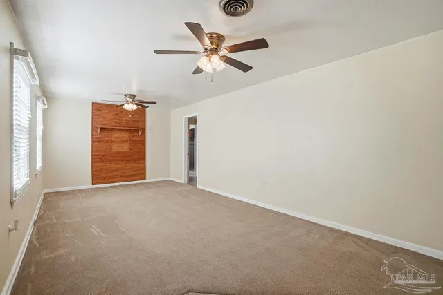 a view of an empty room with a ceiling fan