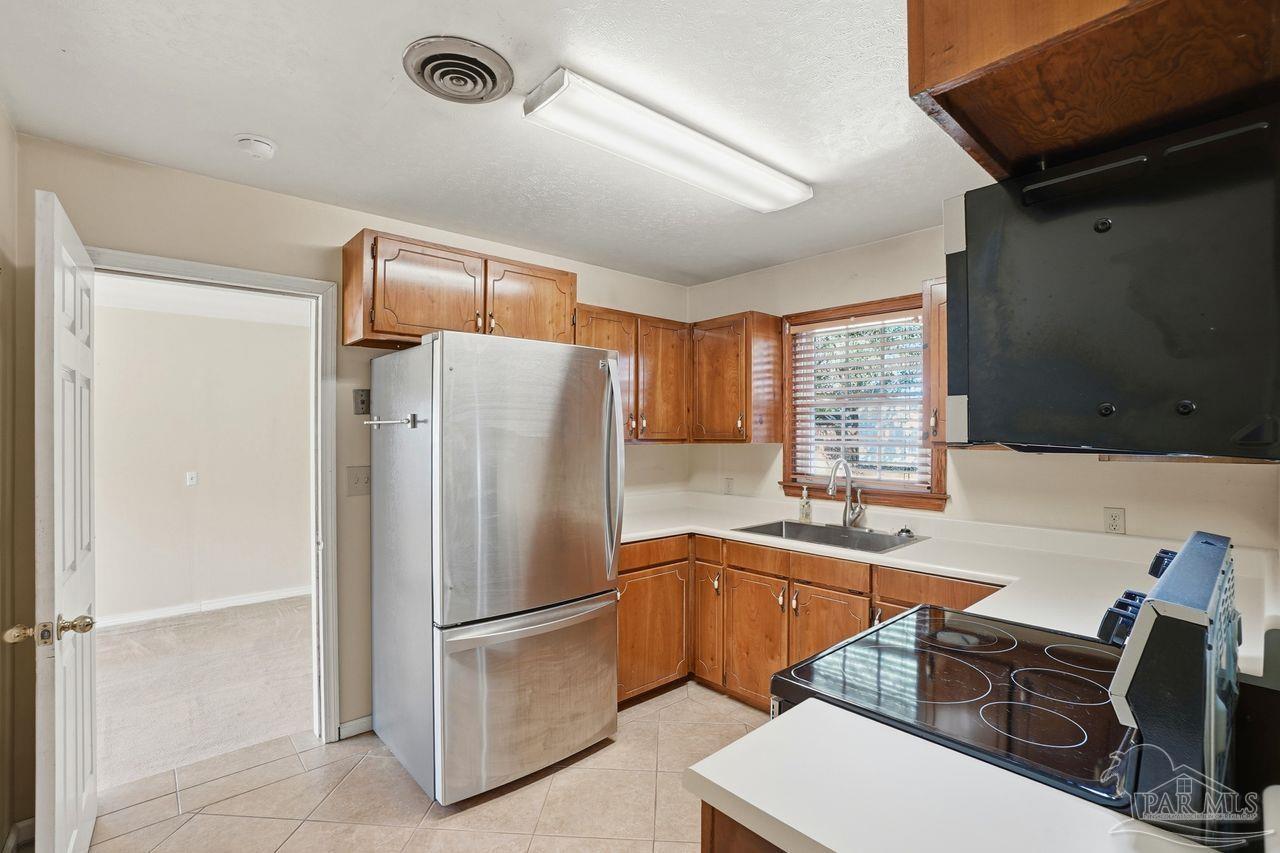 6444 Walnut Street Milton, FL 32570 - Photo 9 of 33 a kitchen with stainless steel appliances a refrigerator and a sink