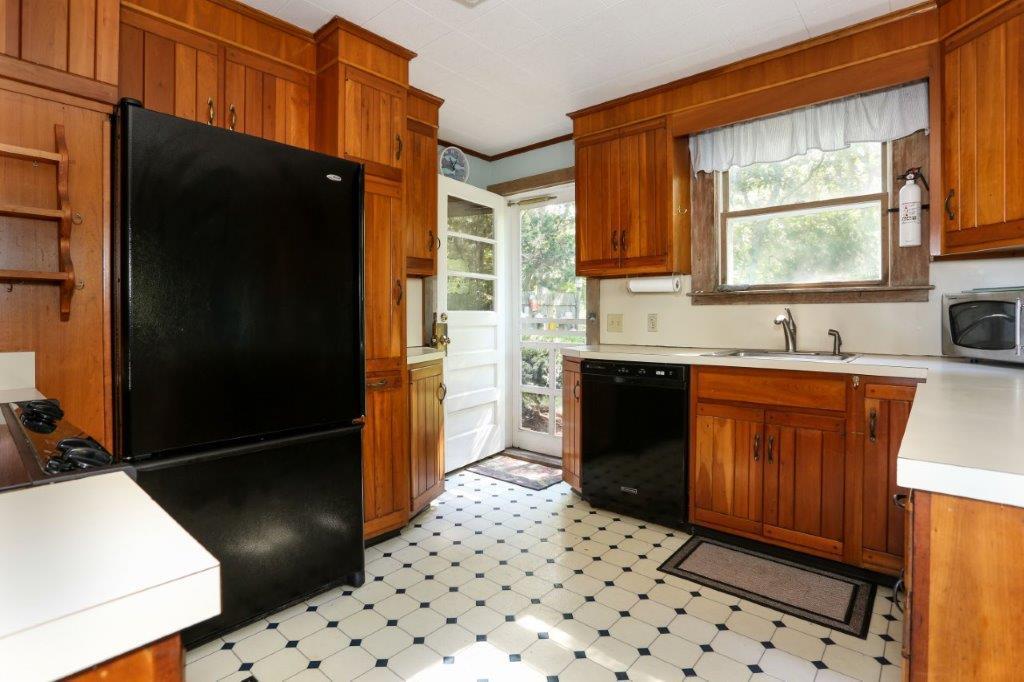 114 Quaker Road Falmouth, MA 02540 - Photo 11 of 35 a kitchen with a sink a refrigerator and wooden cabinets