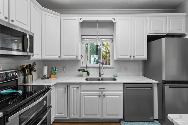 a kitchen with white cabinets and appliances