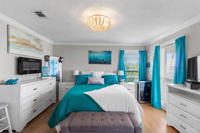 a spacious bedroom with a bed and a flat screen television