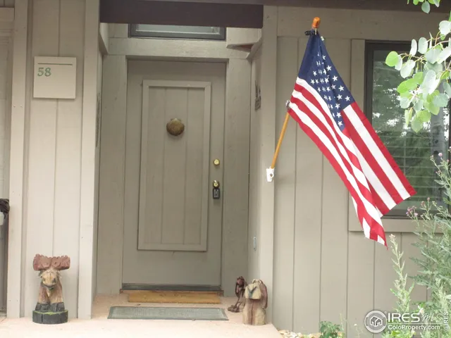 a view of an empty room with wooden floor fireplace and a window