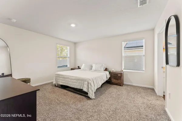 a spacious bedroom with a bed and a window