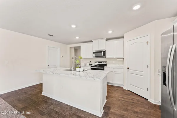 a kitchen with stainless steel appliances a refrigerator sink and microwave