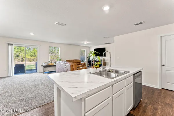 a kitchen with sink cabinets and living room