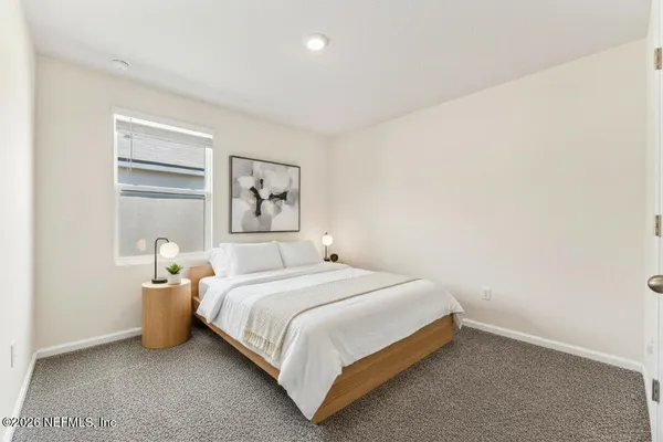 a bedroom with a bed and painting on the wall