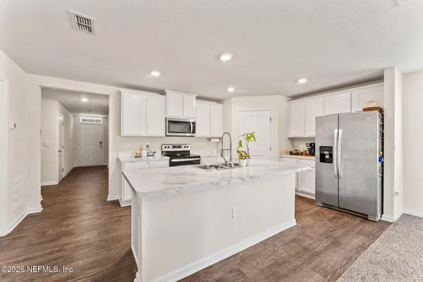 a kitchen with stainless steel appliances a refrigerator stove microwave and cabinets