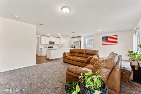 a living room with furniture and a kitchen view