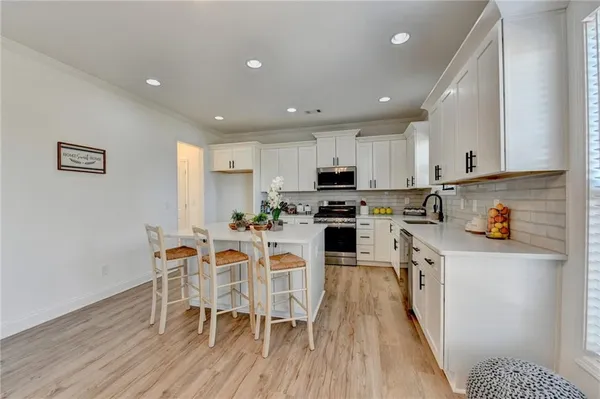 a kitchen with white cabinets stainless steel appliances and sink