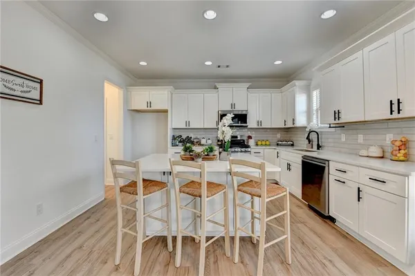 a kitchen with stainless steel appliances granite countertop a stove sink microwave and cabinets