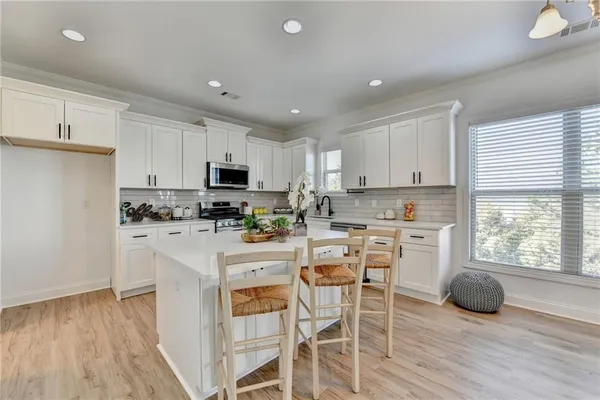 a kitchen with kitchen island granite countertop a sink cabinets and wooden floor