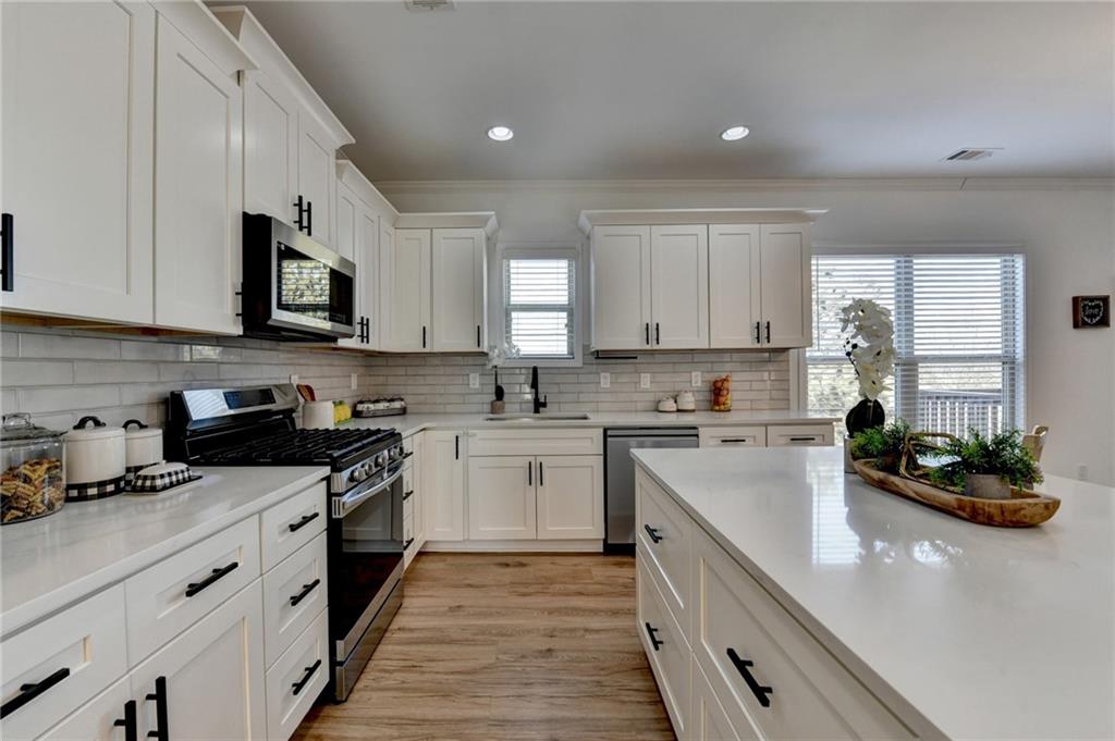 3670 Baxley Ridge Drive Suwanee, GA 30024 - Photo 25 of 64 a kitchen with stainless steel appliances granite countertop a stove sink microwave and cabinets