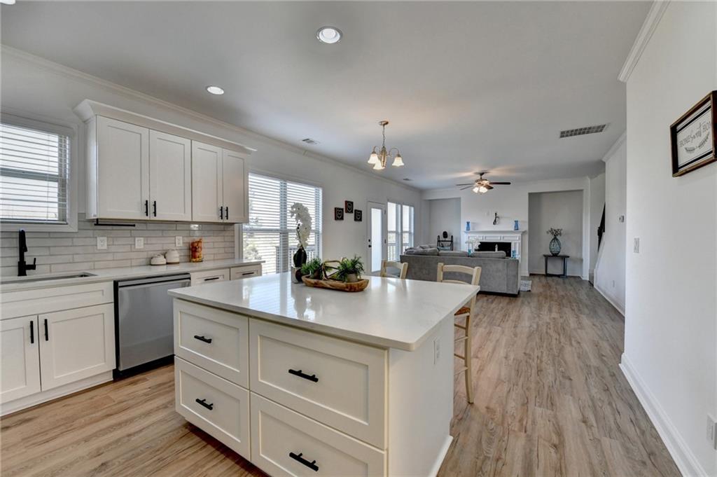3670 Baxley Ridge Drive Suwanee, GA 30024 - Photo 26 of 64 a kitchen with kitchen island granite countertop a sink cabinets and wooden floor