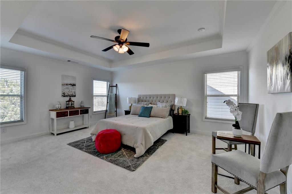 3670 Baxley Ridge Drive Suwanee, GA 30024 - Photo 34 of 64 a spacious bedroom with a bed a couch and a chandelier