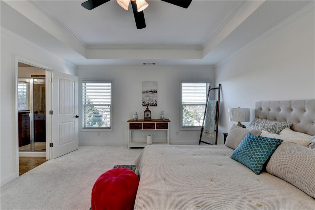 3670 Baxley Ridge Drive Suwanee, GA 30024 - Photo 35 of 64 a spacious bedroom with a bed a couch and a window