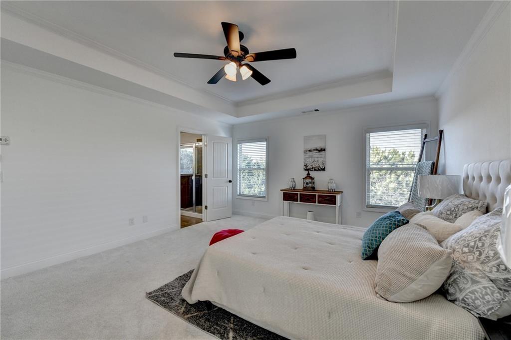 3670 Baxley Ridge Drive Suwanee, GA 30024 - Photo 36 of 64 a bed room with a bed and a chandelier