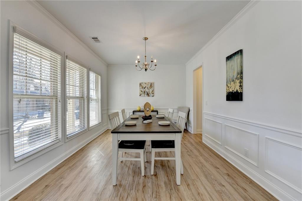 3670 Baxley Ridge Drive Suwanee, GA 30024 - Photo 5 of 64 a dining room with furniture a chandelier and wooden floor
