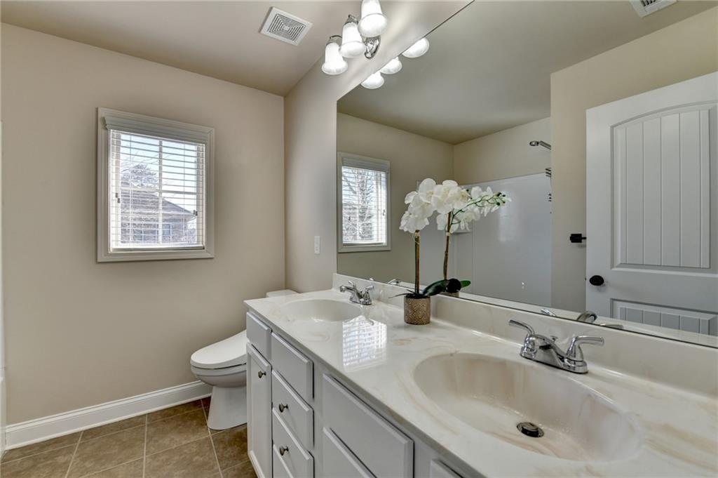 3670 Baxley Ridge Drive Suwanee, GA 30024 - Photo 53 of 64 a bathroom with a toilet a sink and a mirror